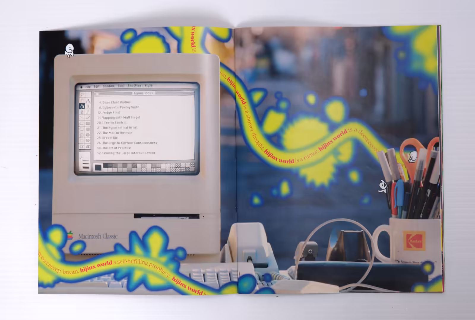 Hijinx World magazine spread photo. Classic Macintosh computer displaying the Table of Contents, surrounded by yellow gloop and hidden figures.