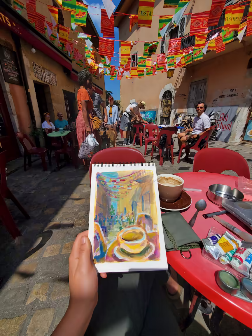 Sitting outside a cafe, with a gouache painting of the scenery