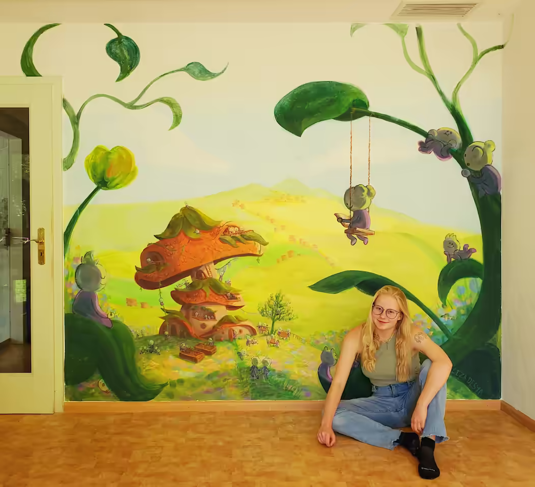 Liza sitting in front of mushroom house fantasy mural