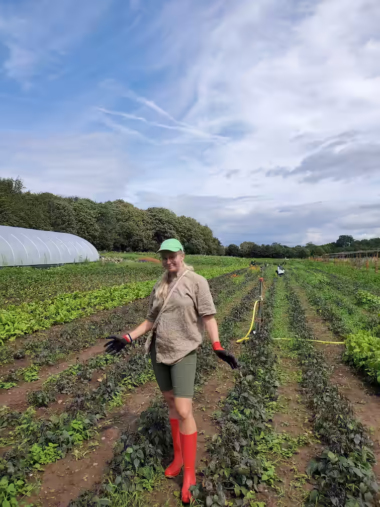Liza in rubber boots, standing on Bhaktivedanta Farm